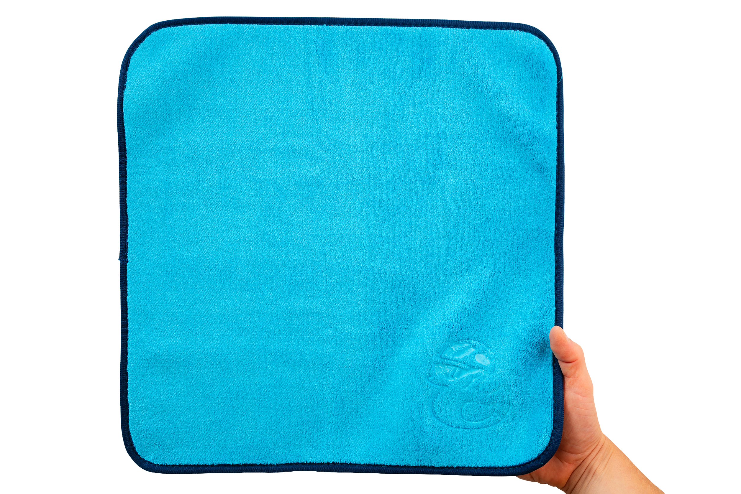 Eine Hand hält das Mikrofasertuch – Premium 800 g/m² – ein quadratisches, hellblaues Mikrofasertuch mit dunkelblauem Rand und einem dezent geprägten Logo in einer Ecke, abgebildet vor weißem Hintergrund.